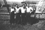 Jewish youth in hiding pose with other agricultural workers in front of a hay wagon on a farm in Treves.
