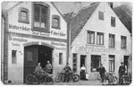 Josef Zwienicki stands in front of his bicycle shop amid several customers.