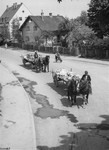 Carts laden with corpses travel through the town of Dachau en route to a burial site.