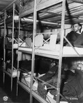 Survivors lie in multi-tiered bunks in the infirmary in the Dachau concentration camp soon after its liberation.