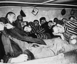 Survivors in Dachau packed into overcrowded sleeping quarters, where 7 men had to share 2 small beds.
