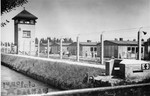 A view of the electrified barbed wire fence, the moat and the watch tower in Dachau.