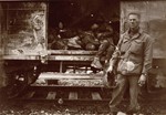 An American soldier poses next to one of the open railcars of the Dachau death train.