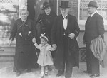 Elizabeth Reiss, a young Jewish girl, leaves a house accompanied by her maternal grandmother, Renee Rubens, great grandparents, and great-uncle, Jaap Trompeter.
