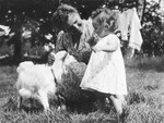 Marguerite-Rose Birnbaum and her rescuer, Marie-Josephe Dincq, pet a baby goat.