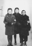 Three girls wearing armbands pose in the Chrzanow ghetto.