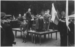 A Zionist leader delivers a speech from a makeshift podium that is ringed by uniformed Jewish police at a political demonstration in the Wetzlar displaced persons camp.