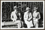 Three Czech  women of Jewish origin sit together on a ledge in front of a metal fence in Nachod.