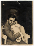 Close-up portrait of a Czech-Jewish father holding his infant daughter.