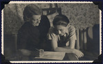 A mother and son, both survivors of Theresienstadt, study a document in their apartment in postwar Prague.