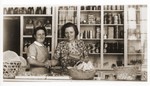 Two German Jewish refugee women stand behind the counter of the Elite Provision Store (delicatessen) in Shanghai.