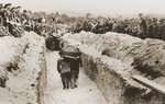 Pallbearers carrying the victims of the Kielce pogrom, place the coffins in a mass grave at the Jewish cemetery.