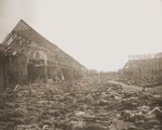 View of the main street of the Nordhausen concentration camp, outside of the central barracks (Boelke Kaserne), where the bodies of prisoners have been laid out in long rows.