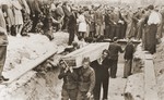 Pallbearers, some of whom are Polish soldiers, place the coffins of the victims of the Kielce pogrom in a mass grave at the Jewish cemetery.