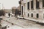German soldiers patrol a street in Czestochowa, where dead bodies lie strewn along the pavement.