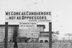 A sign in front of a U.S. military installation in Berlin features a quotation by General Dwight Eisenhower that reads: "We Come as Conquerors...Not as Oppressors."