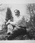 Portrait of pastor Edouard Theis sitting in the grass.
