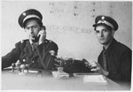 Two Jewish policemen at work in their office at the Bindermichl displaced persons camp.
