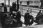 A Jewish family climbs the stairs to the train platform at the railway station during a deportation action from the Krakow ghetto.