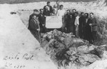 Jewish survivors stand in an opened mass grave among the exhumed bodies of the victims of a mass shooting in Biala Podlaska.