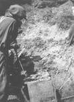 Romanian workmen exhume a coffin containing the body of a Jew killed in the ghetto in Dej.