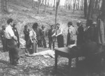 Romanian workmen examine the body of a Jew killed in the ghetto in Dej.