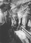 Jozsef Gecse, a Hungarian Nazi who was active in the ghetto, examines the body of a Jew killed in the ghetto in Dej.