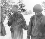 Tahae Sugita (right), a Japanese-American soldier with the 522nd Field Artillery battalion, stands next to a concentration camp survivor he has just liberated on a death march from Dachau.