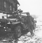 A Japanese-American soldier poses next to his jeep in the town of Waakirchen, where the 522nd Field Artillery Battalion set up a temporary field hospital for survivors of a Dachau death march.