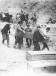 Romanian workmen carry a coffin containing the body of a Jew killed in the ghetto in Dej.