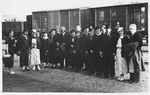 Group portrait of relatives and friends of the Jam family in front of a train.