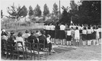 Supporters of the Zuen children's home watch the girls perform a flag-raising ceremony.