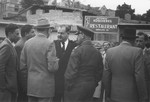 Philipp Auerbach talks to a group of men, including representatives of the military government outside the Astoria Kosher restaurant on the Moehlstrasse.