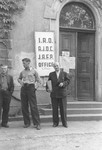 Three men stand outside a building in the Munich Warner-Kaserne (barracks) displaced persons transit camp where the offices of the IRO (International Refugee Organization,  AJDC (American Joint Distribution Committee) and JAFP (Jewish Agency for Palestine) were located.