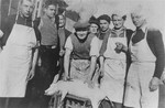 A group of kitchen workers in the Gurs concentration camp pose with a slaughtered pig.