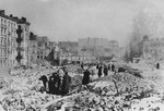 Local inhabitants wade through ruins in Warsaw following the surrender of the city.