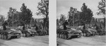 Stereoscopic photograph of German tank drivers turning to face a saluting Adolf Hitler, as they roll past the speakers' podium, during a victory parade in Warsaw celebrating the German conquest of Poland.