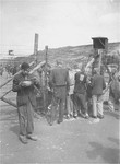 Male and female Mauthausen survivors converse with one another through the barbed-wire fence that separates the "sick camp" from the other sections of the camp.