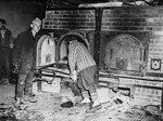 Survivors in Mauthausen open one of the crematoria ovens for American troops who are inspecting the camp.