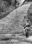 A Soviet honor guard stands next to the stone "stairs of death" (Todesstiege) in the Wiener Graben quarry at the Mauthausen concentration camp.