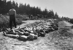 The bodies of former concentration camp inmates are laid out in a row in preparation for burial.