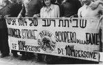 Jewish DPs in La Spezia harbor are gathered behind a banner announcing their hunger strike to protest British immigration policy in Palestine.