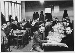 Jewish refugees from the Third Reich eat a meal in the dining hall of a refugee center in Luxembourg sponsored by the ESRA Jewish social welfare organization.