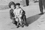 Jacob Zajac, a soldier in the Jewish Brigade, poses with a very young survivor in the Bergen-Belsen concentration camp.