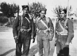 Three members of the Jewish Brigade and members of the British 8th Army pose on a street in Italy.