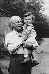 A Jewish grandfather poses outside with his baby grandson.