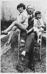 Doris and Eva Bermann sit on their grandfather's lap on a roof garden.