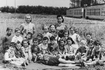 Kindergarteners in the Wels DP camp pose in an open field.