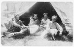 New pioneers pose next to their tent in a kibbutz in Palestine.