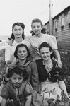 Five girls in the Wels displaced persons' camp pose in front of a barracks.